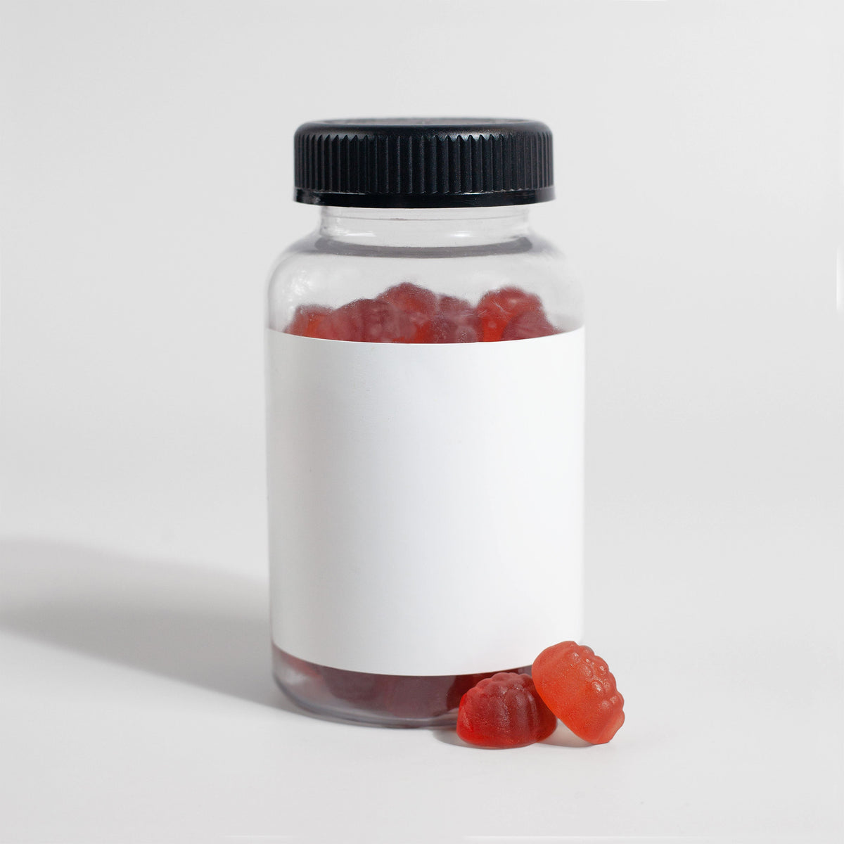 Clear jar of gummy supplements on a white background